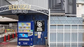 A vending machine with a Pepsi logo, a sign for 'KOUZUKI', and a blue door with a black sign.