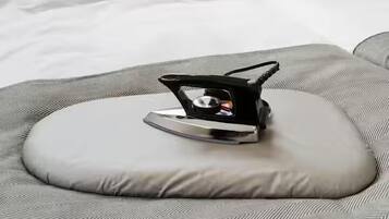 A bed with a gray patterned bedspread and a gray pillow.