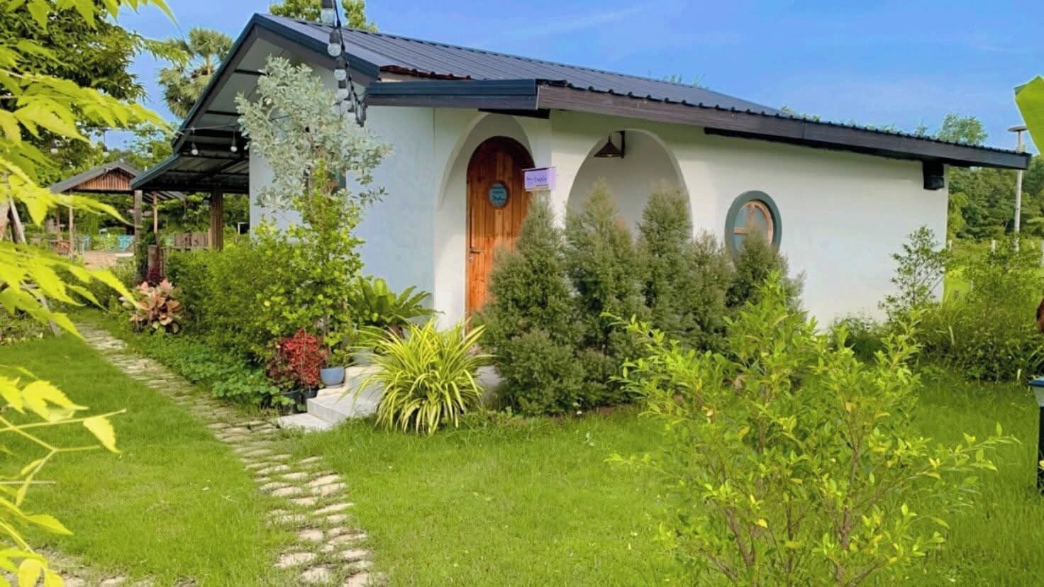A small, single-story building with a sloped roof, a wooden door, and a small porch area.