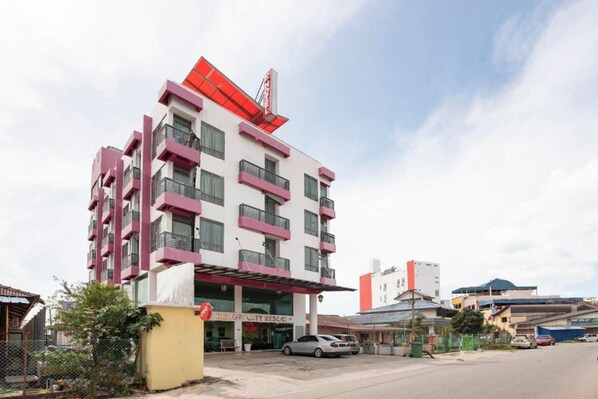 Un hôtel à plusieurs étages, doté de balcons, d’un auvent rouge et d’une enseigne indiquant « BENGH CITY RESORT ».
