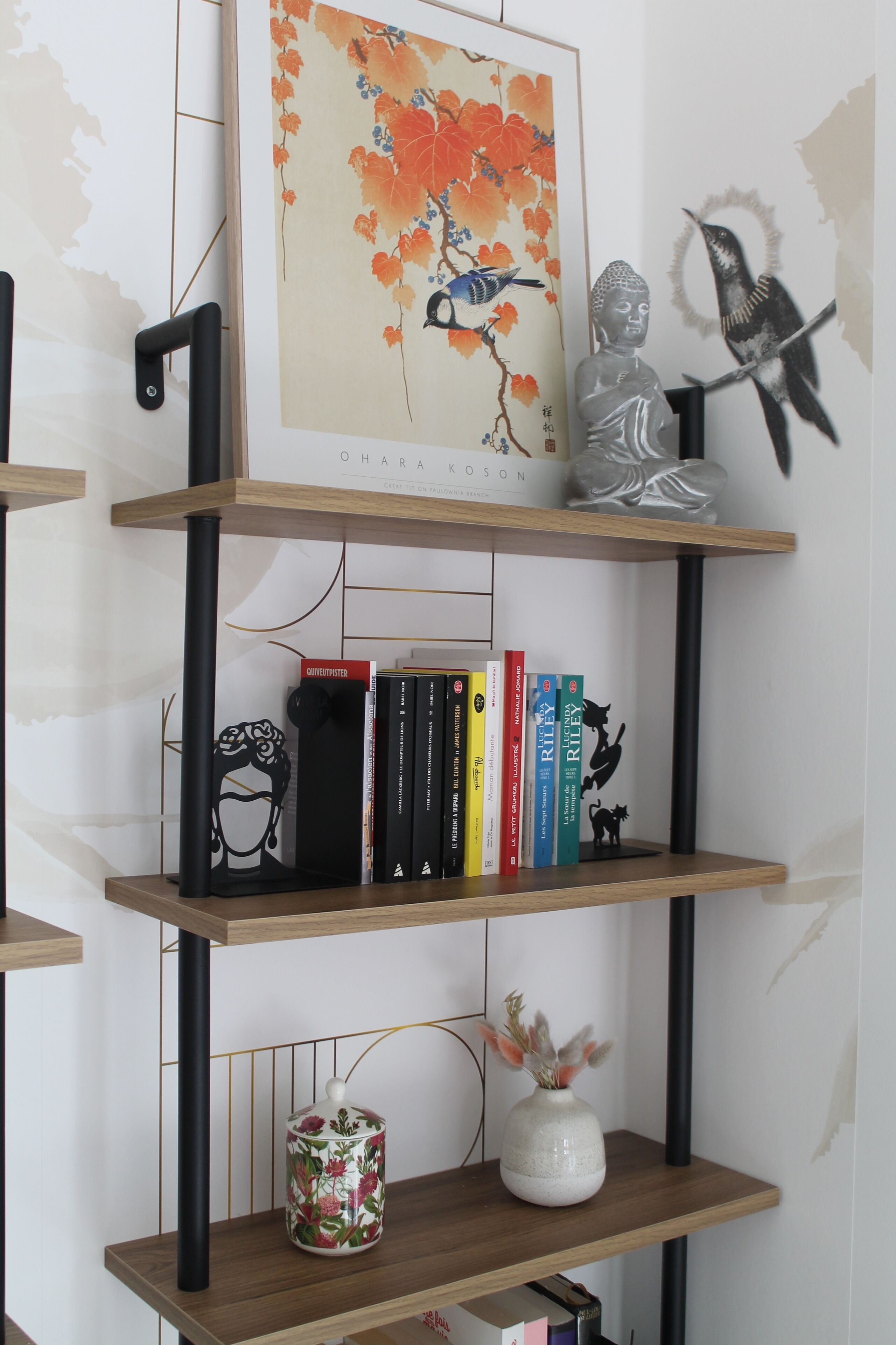 Ein Bücherregal mit Büchern, einer Vase und einer Buddha-Statue.