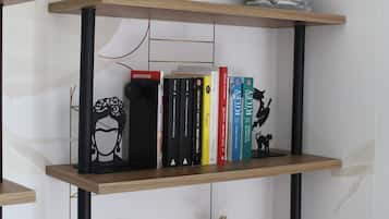 Ein Bücherregal mit Büchern, einer Vase und einer Buddha-Statue.