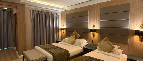 A modern hotel room with two beds, a wooden headboard, and a skylight.