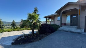 A modern house with a covered porch, a stone pathway, and a landscaped garden with a palm tree. - 2 acres lot with Mt Rainier view (Edgewood)