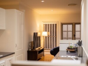 A narrow hallway with a traditional Japanese-style shoji screen door, a small table with a lamp, and a desk with a computer.