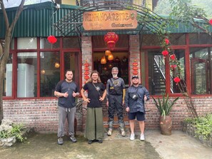 A group of people standing in front of a restaurant named "NINHO RETREAT." - Ninh Hoa Retreat (Tay Hoa Lu)
