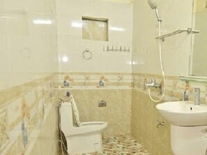 A small bathroom with a toilet, sink, and shower. - Ninh Hoa Retreat (Tay Hoa Lu)