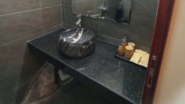 A bathroom with a marble sink, a towel rack, and a mirror. - Ninh Hoa Retreat (Tay Hoa Lu)