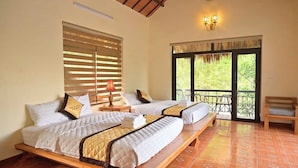 A room with two beds, a balcony, and a view of greenery. - Ninh Hoa Retreat (Tay Hoa Lu)