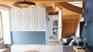 A modern living room with a wooden ceiling, a round wooden coffee table, a sofa, and a TV stand. - LARGE SEASIDE FARMHOUSE FOR 10 PEOPLE (Tréogat)