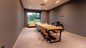 A conference room with a long table, chairs, a sofa, and a large window with a view of greenery. - HOUNDHOTELDAEGUHYUKSIN (Daegu)