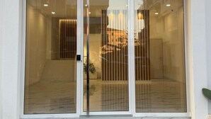 A modern building entrance with large glass doors and a metal gate.