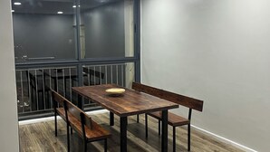 A dining area with a wooden table and benches, a window with a view, and a staircase leading to another level.