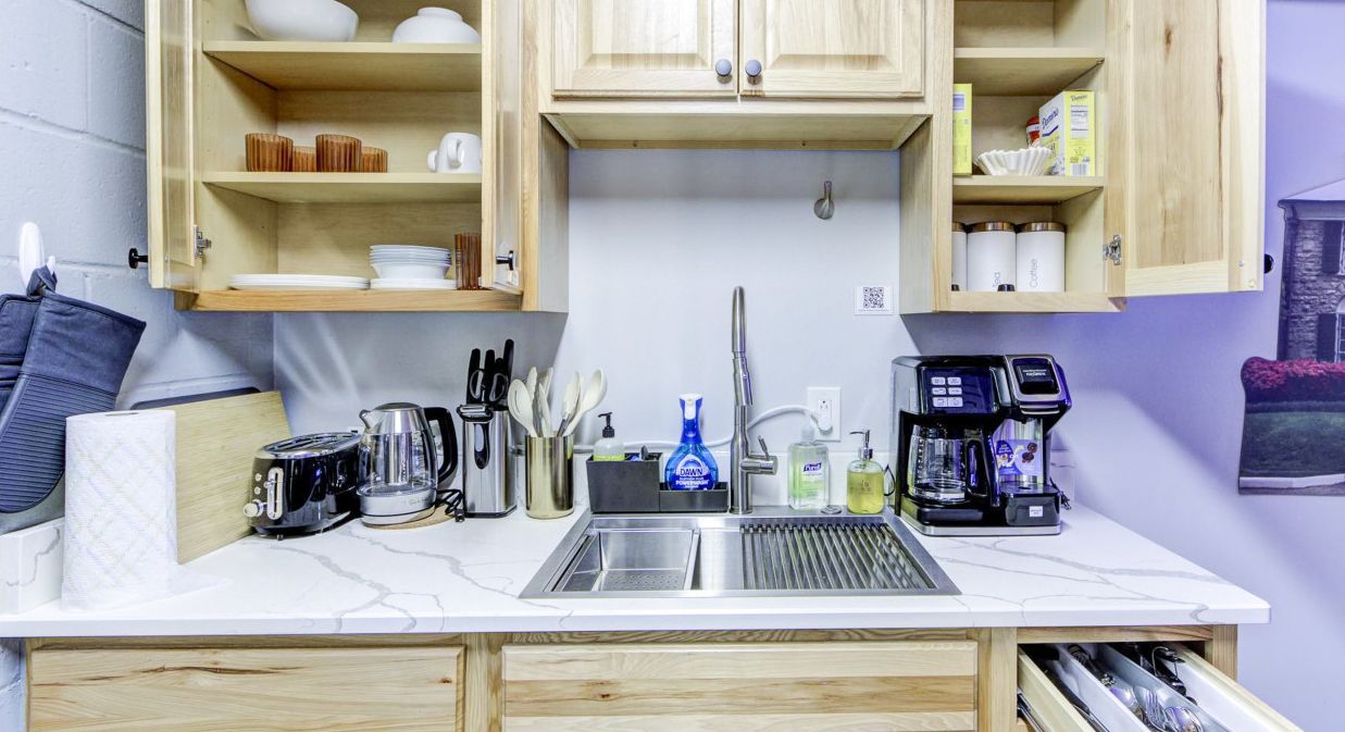 A kitchen with wooden cabinets, a sink, and various kitchen appliances.