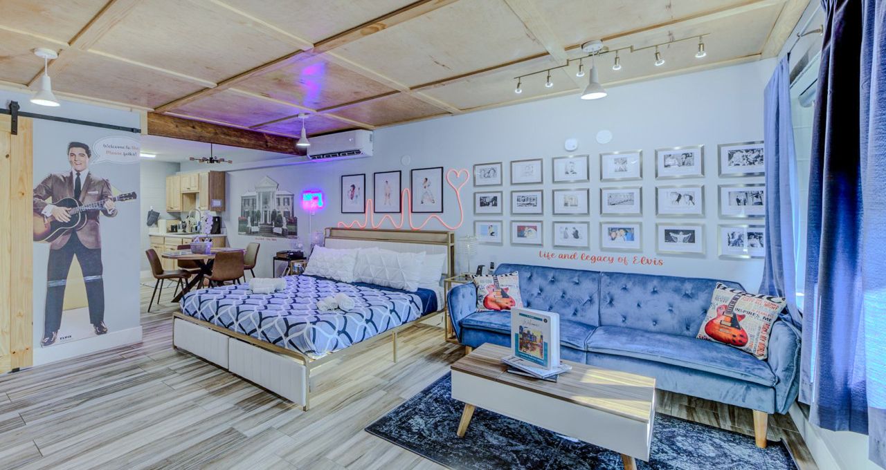 A modern bedroom with a bed, a sofa, and a dining area.