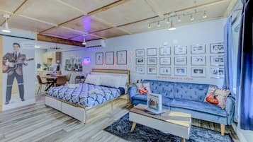 Un dormitorio moderno con cama, sofá y zona de comedor.