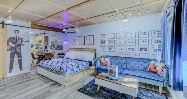 Une chambre moderne avec un lit, un canapé et un coin repas.