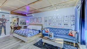 Une chambre moderne avec un lit, un canapé et un coin repas.