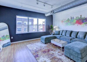 A modern living room with a sectional sofa, a coffee table, and a large window.