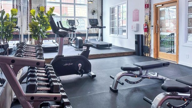 A gym with treadmills, elliptical machines, and dumbbells. - BRAND NEW Modern Spacious Loft in Downtown with free parking (Memphis)