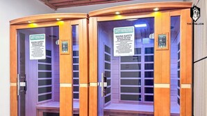 Two sauna rooms with wooden doors, safety instructions, and a control panel.