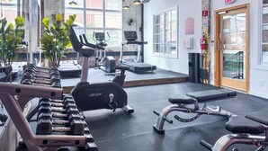 A gym with exercise equipment, a treadmill, and a mirrored wall.