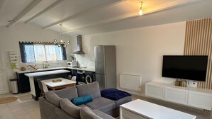 A modern kitchen with a dining area, a sofa, and a TV. - Splendid house in a peaceful setting (Nieul-sur-Mer)
