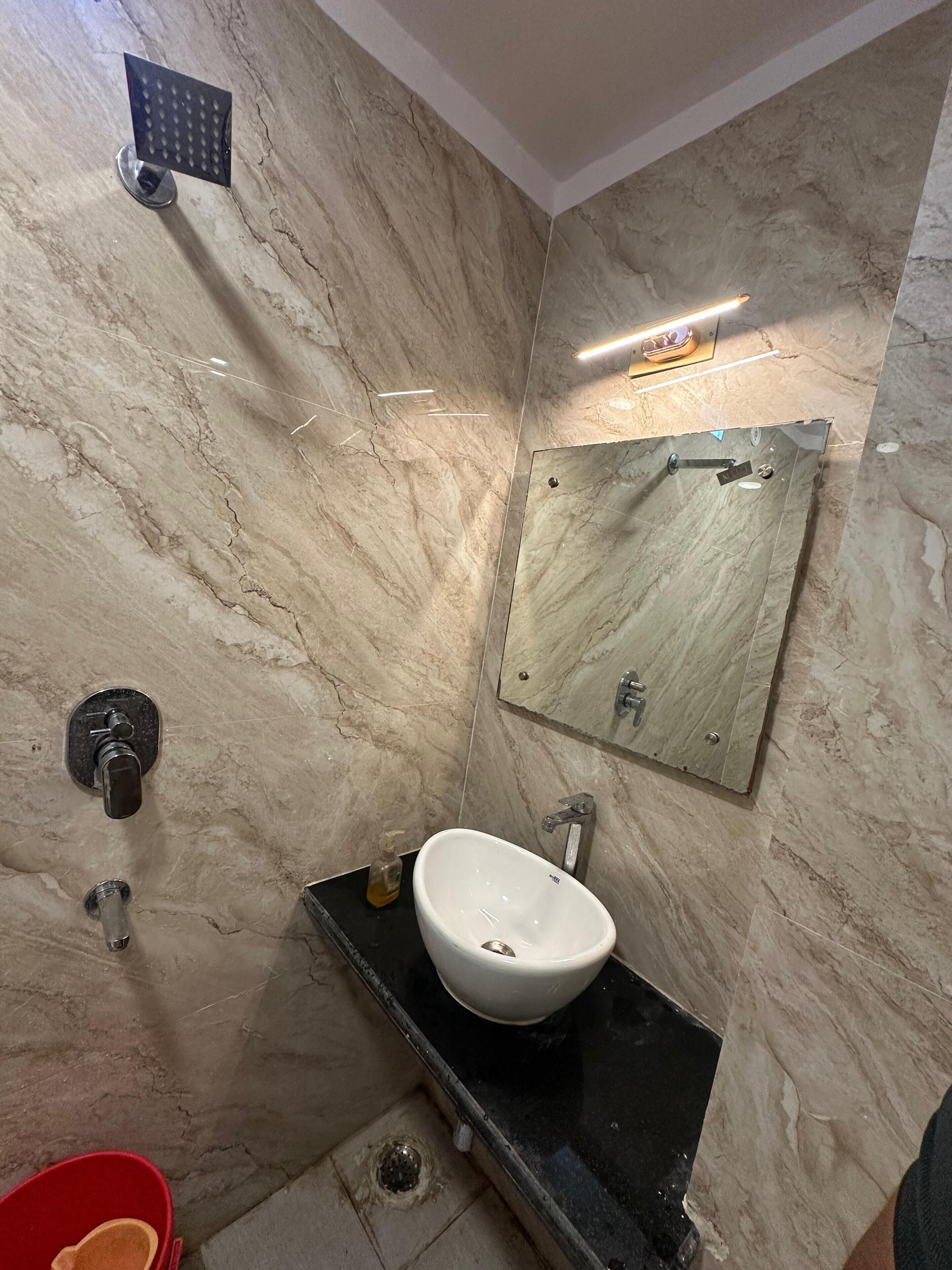 Un baño con lavamanos blanco, un espejo y una ducha.