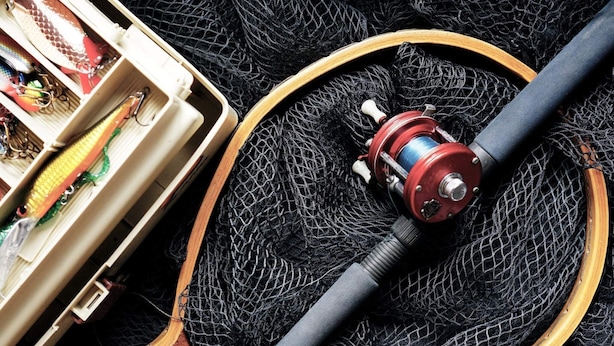 A fishing rod with a reel and a tackle box containing various fishing lures. - 12 Person Holiday Home in Lidsjoberg (Lidsjöberg)