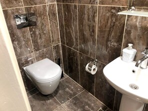 A bathroom with a toilet, a sink, and a shower area. - Istanberry - Joker Studio Apartments (İstanbul)