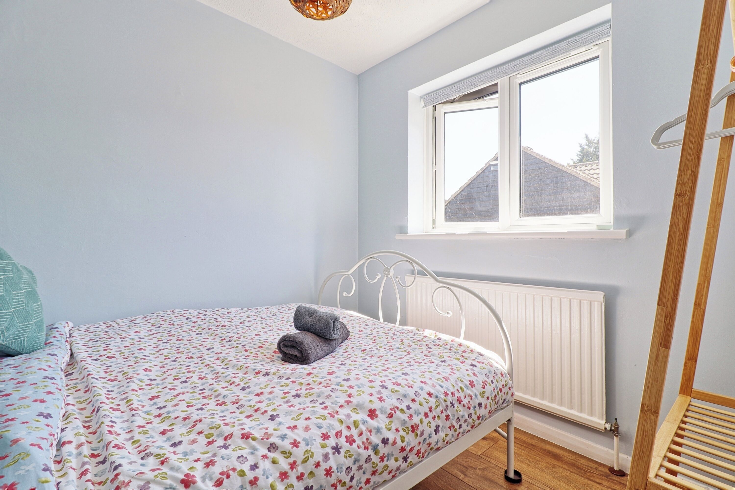 A bedroom with a bed, a window, and a radiator.