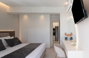 A modern hotel room with a bed, bedside table, and a TV mounted on the wall. - Lux Stay at Villa 10Α and 10B•Elysian Residences Heraklion (Iraklio)