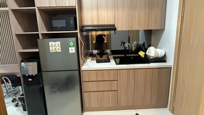 Une cuisine compacte équipée d’un four à micro-ondes, d’un réfrigérateur et d’un évier.