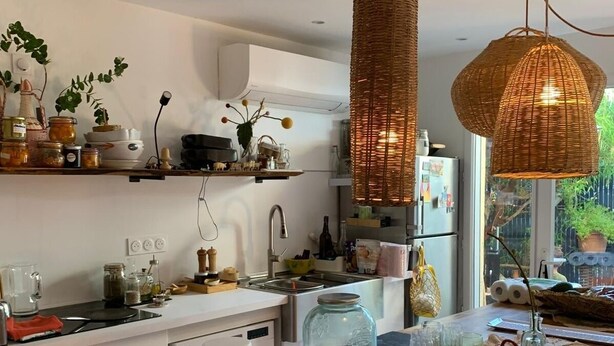 A modern kitchen with white cabinetry, a wooden countertop, and a hanging wicker light fixture. - Large studio with garden: a haven of freshness and greenery right in the center of town (Cavalaire-sur-Mer)