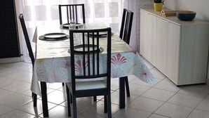Uma sala de jantar com uma mesa, cadeiras e um armário.
