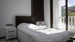 A bedroom with a bed, a nightstand, a wall-mounted TV, and a balcony with a railing. - Huge 5BR Villa with Rooftop Lounge/BBQ ZONE/PRIVATE POOL in delightful Chlorakas (Chlorakas)