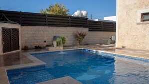 A swimming pool with a tiled edge, a water feature, and a stone wall. - Huge 5BR Villa with Rooftop Lounge/BBQ ZONE/PRIVATE POOL in delightful Chlorakas (Chlorakas)