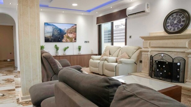 A modern living room with a sectional sofa, a recliner, and a fireplace. - Huge 5BR Villa with Rooftop Lounge/BBQ ZONE/PRIVATE POOL in delightful Chlorakas (Chlorakas)