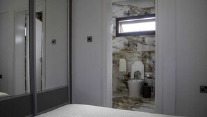 A bedroom with a large mirror, a bed, and a view into a bathroom with a marble wall and a sink. - Huge 5BR Villa with Rooftop Lounge/BBQ ZONE/PRIVATE POOL in delightful Chlorakas (Chlorakas)