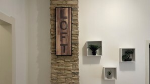A stone wall with a wooden sign reading "HOTEL" and three small plant displays on the wall. - Cozy & Stylish Townhouse in Central Niš w/ 2BR • WiFi • AC (Niš)