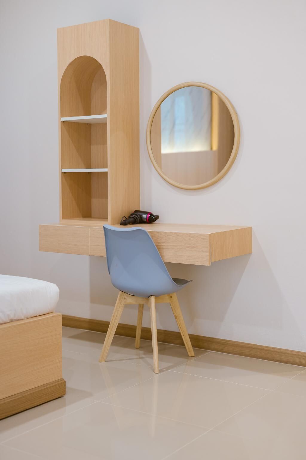 A study area with a desk, chair, and a mirror.
