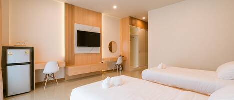 A hotel room with two beds, a desk, a chair, a TV, and a wardrobe.