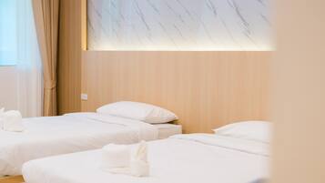 A hotel room with two beds, wooden headboard, and a marble-patterned wall.