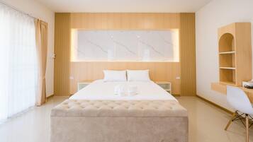 A modern bedroom with a large bed, a wooden headboard, a marble wall, and a built-in desk with a chair.