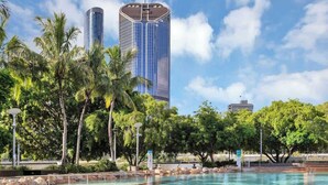 A swimming pool with rocks, palm trees, and modern buildings in the background. - South Bank Sensational! ~ 2Bed/2Bath/1Car/Pool! (South Brisbane)