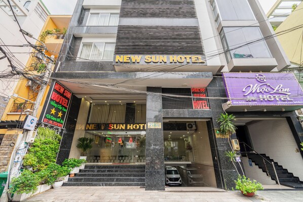L’entrée d’un hôtel, avec une enseigne indiquant « New Sun Hotel » et une autre indiquant « Môc Lan Hotel ».