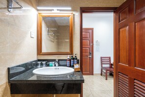 Une salle de bain avec un lavabo en marbre, une porte en bois et un miroir.