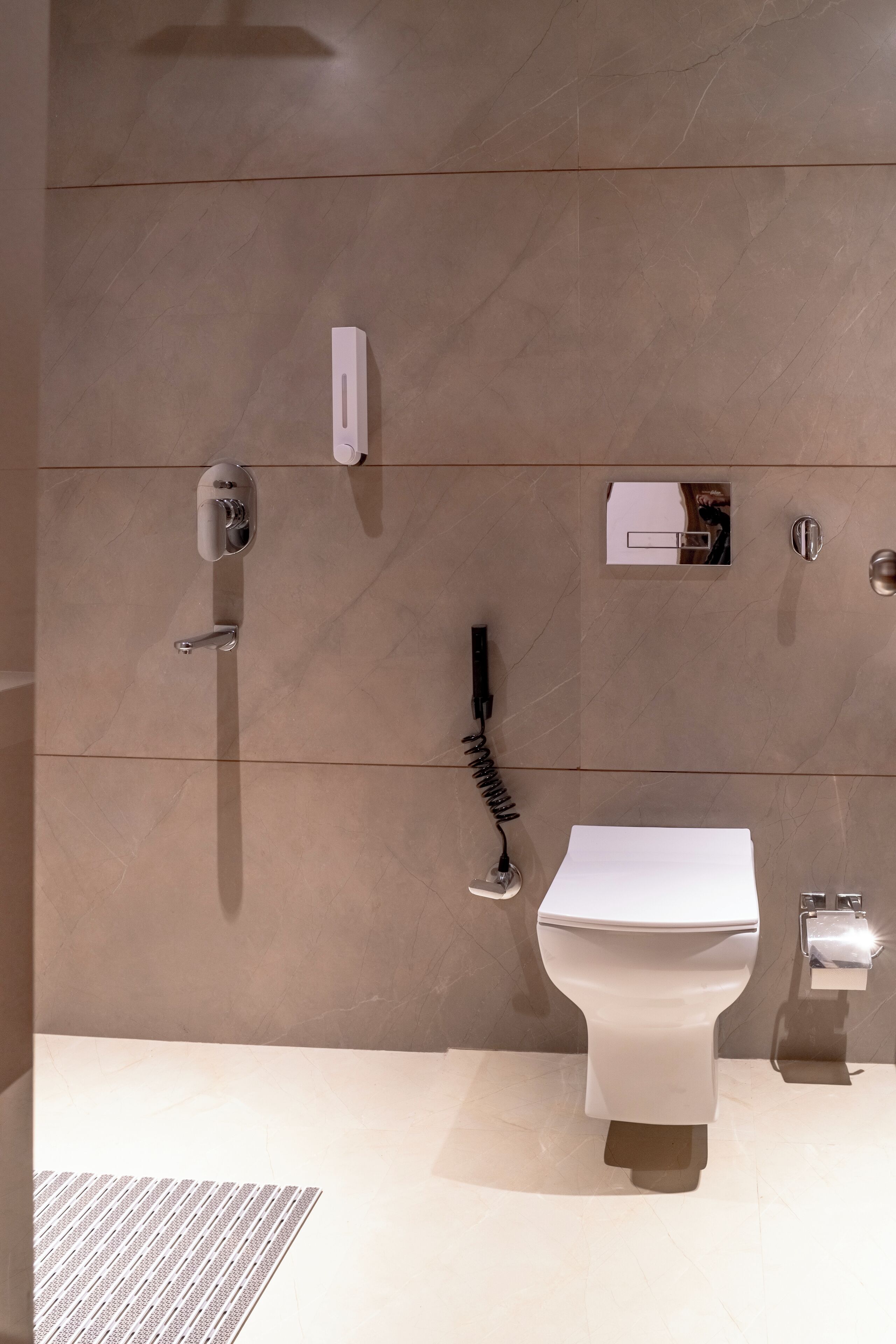 A modern bathroom with a toilet, bidet, and towel rack.