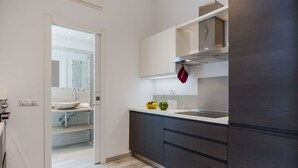 A modern kitchen with dark cabinetry, a stainless steel range hood, and a white countertop. - Cosy apartment for 4 people with A/C, WIFI, TV, patio and pets allowed (Camaiore)