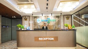 A reception desk at The Riverstone Inn with a marble floor, a chandelier, and a sign indicating the name of the hotel. - The Riverstone Inn - Near India Expo Centre & Mart, Greater Noida (Greater Noida)